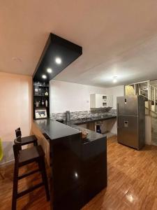 uma cozinha com um balcão preto e um frigorífico em Casa San Andrés Arenas I em Pisco