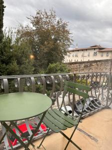 a green table and chairs on a balcony at Botta 9 in Bergamo