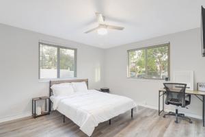 ミラマーにあるSpacious and luxurious home centrally located between Miami and Ft. Lauderdaleの白いベッドルーム(ベッド1台、デスク付)
