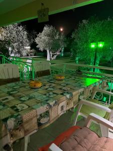 einen Tisch und Stühle auf einer Terrasse in der Nacht in der Unterkunft TERRY'S VILLA in Mákri