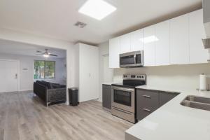 een keuken met witte kasten en een fornuis met oven bij Spacious and luxurious home centrally located between Miami and Ft. Lauderdale in Miramar
