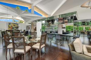 a dining room with tables and chairs in a building at Canyon Palms Estate- Ultra-Luxe, Pool, Spa, Firepit, Outdoor Kitchen & More in Palm Springs