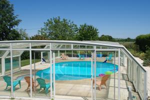 a glass enclosure around a swimming pool in a house at Manoir Les Touches 
