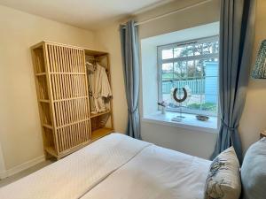 1 dormitorio con cama y ventana en No 2 Ramageton, en Troon