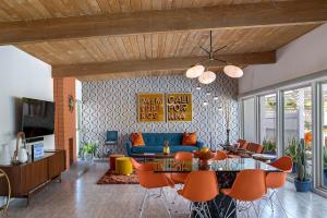 a living room with a blue couch and orange chairs at On The Rox- Luxury Refreshing Mid-Century Mod- Pool, Spa, Firepit, Outdoor Kitchen & More in Palm Springs