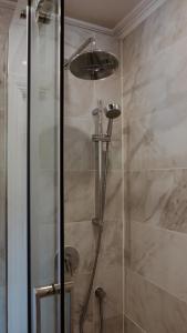 um chuveiro com uma porta de vidro na casa de banho em Auberge des Korrigans em Stoneham