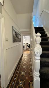 a stairway with a white railing and a stair case at Victorian/modern house in Newport