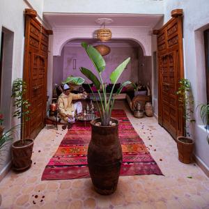 マラケシュにあるRiad Taziriの植物を植えた大花瓶のある部屋