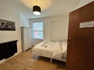 a small bedroom with a bed and a fireplace at Victorian/modern house in Newport