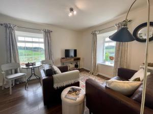 a living room with two couches and a table and window at No 2 Ramageton in Troon