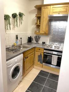 a kitchen with a sink and a dishwasher at Elegant & Cozy Downtown Flat in London