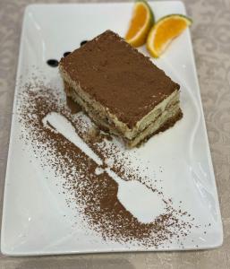 HOTEL UJVARA في Belsh-Qendra: قطعة من كعكة الشوكولاته على طبق أبيض