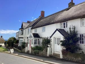 a group of white houses on the side of a street at Foxley Cottage in Charmouth