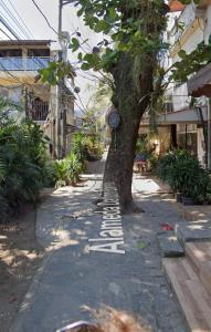 a sidewalk with a tree and a sign on it at POUSADA DAS COLONIAS in Rio de Janeiro