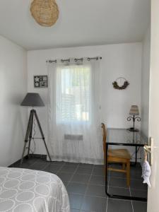 Schlafzimmer mit einem Bett, einem Tisch und einem Fenster in der Unterkunft Maison Eugenie Arena, Gendarmerie, Rocade in Bouliac