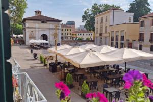 a group of tables and chairs with umbrellas at Elegante alloggio in casa storica-Borgo Portello in Padova