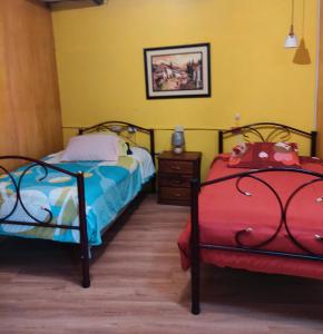 2 camas en una habitación con paredes amarillas y suelo amarillo en Casa Bella Vista, en Cuenca