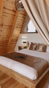 a bed in a room with a wooden ceiling at Meona Villa Bungalov in Ardeşen