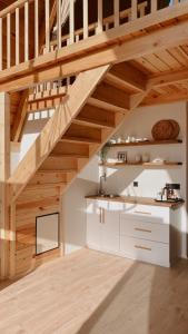 a kitchen with white cabinets and wooden stairs at Meona Villa Bungalov in Ardeşen