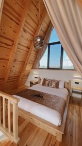 a bedroom with a large bed in a wooden ceiling at Meona Villa Bungalov in Ardeşen