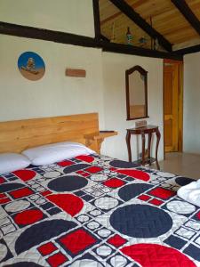 ein Schlafzimmer mit einem Bett mit gemusterter Tagesdecke in der Unterkunft Rancho Tierra Firma San Miguel de Bolivar in San Miguel