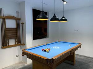 a pool table in a room with three lights at Casa San Andrés Arenas con sala de billar in Pisco