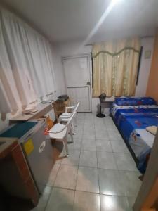 1 dormitorio con 1 cama, escritorio y sillas en Estudio en Garzota con Cocina y lavanderia Wifi, en Guayaquil