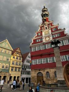 Un alto edificio rosso con una torre dell'orologio. di nah zur S-Bahn und Altstadt a Esslingen