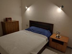 una camera con un grande letto e un comodino con un letto sidx sidx. di CHESS Apartment a Ventspils