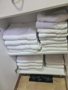 a closet filled with white towels on a shelf at Vila Jovana - SELF CHECK IN in Čačak