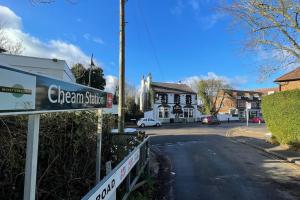 a sign for a cream store on a street at KingsHouse In Cheam Village in Cheam