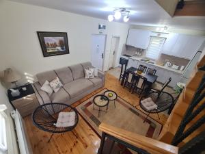 a living room with a couch and chairs and a kitchen at Vila Jovana - self check in in Čačak