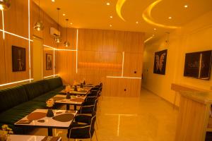 un ristorante con tavoli lunghi e un divano verde di Elcastillo Homes a Lagos