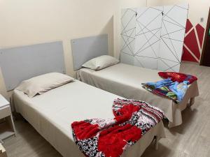 - 2 lits dans une petite chambre avec couverture dans l'établissement Flat Paladium, à São Vicente