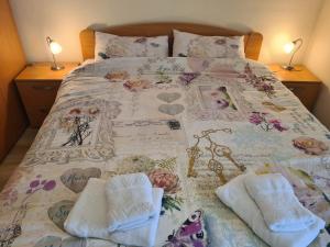 Una cama con una manta y toallas. en Vila Jovana - SELF CHECK IN en Čačak