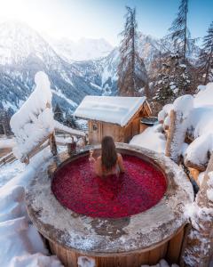 a woman in a hot tub in the snow at Hotel Chalet Al Foss in Vermiglio