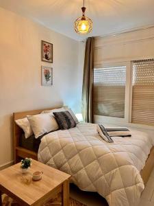 a bedroom with a bed and a table and a window at Studio de charme Centrale Rabat in Rabat