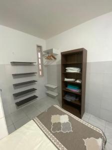 a bedroom with a rug on the floor and a closet at Temporada CG - Casinha da Vovo in Campina Grande