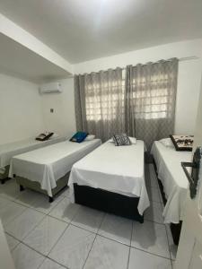 sypialnia z 2 łóżkami i oknem w obiekcie Temporada CG - Casinha da Vovo w mieście Campina Grande