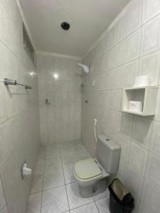 a white bathroom with a toilet and a shower at Temporada CG - Casinha da Vovo in Campina Grande