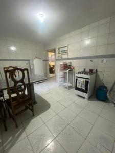 a kitchen with a stove and a chair in it at Temporada CG - Casinha da Vovo in Campina Grande