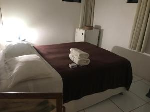 a bed with towels sitting on top of it at POUSADA DAS COLONIAS in Rio de Janeiro