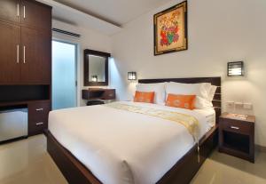 
a bedroom with a large bed and a large window at Lotus Tirta Seminyak in Seminyak
