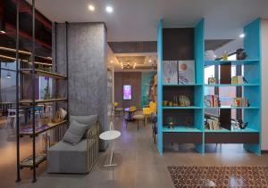 - un salon avec des étagères bleues et un canapé dans l'établissement SOJO HOTEL CAN THO, à Cần Thơ