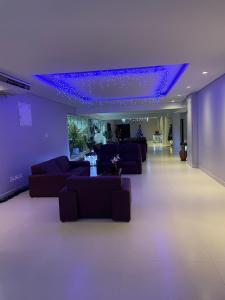 d'un salon avec des canapés et un plafond violet. dans l'établissement Flat Paladium, à São Vicente