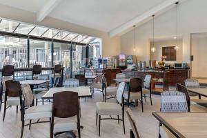 un comedor con mesas, sillas y ventanas en Best Western Plus Executive Inn, en Rowland Heights