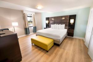 a hotel room with a bed and a yellow stool at Best Western Seaside Inn in Saint Augustine Beach
