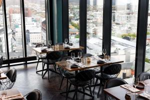 een restaurant met tafels en stoelen en grote ramen bij Scandic Havet in Bodø