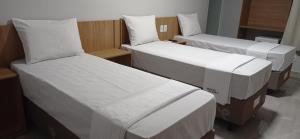 a room with two beds with white sheets at Hotel Bonina in Sao Paulo