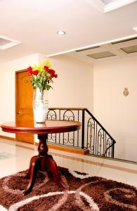 a vase of flowers on a table in a room at Hotel Casa La Riviera in Bogotá